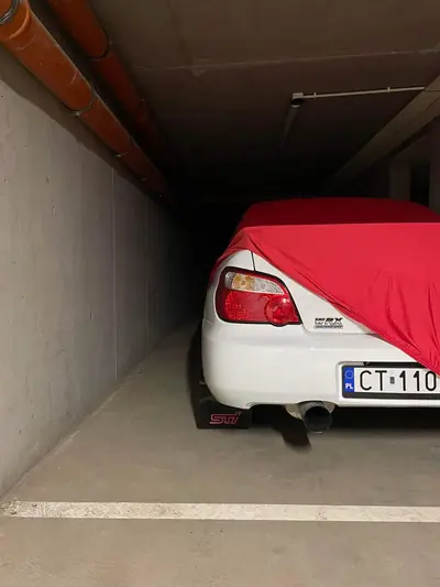 Zakładanie czerwonego pokrowca CarCapes na białe auto