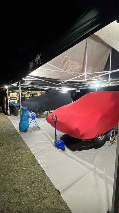 Auto pod czerwonym pokrowcem CarCapes na zawodach