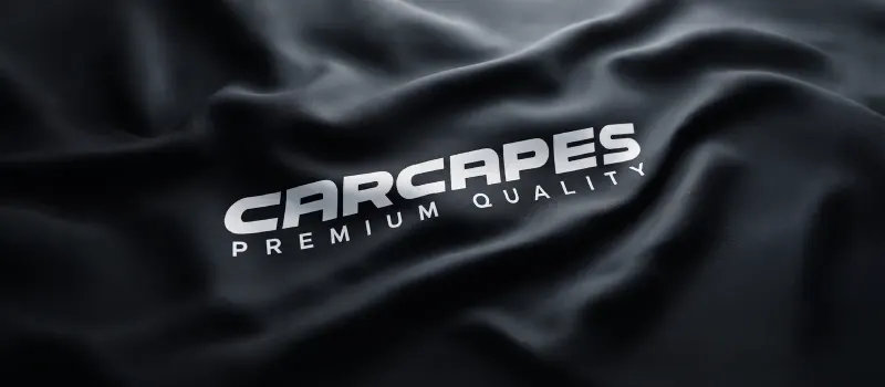 Logo CarCapes na czarnej tkaninie pokrowca, zbliżenie